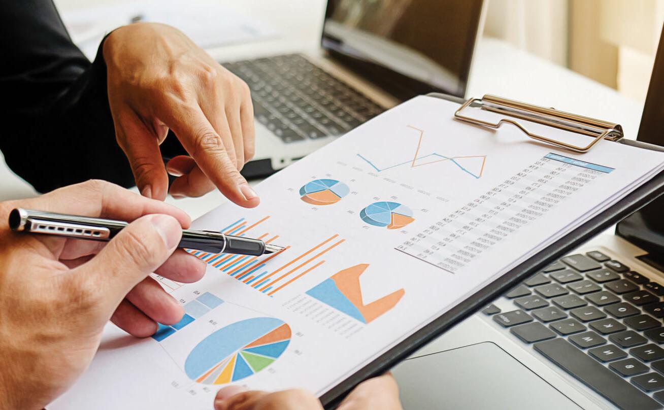 Photo of hands pointing to various pie charts